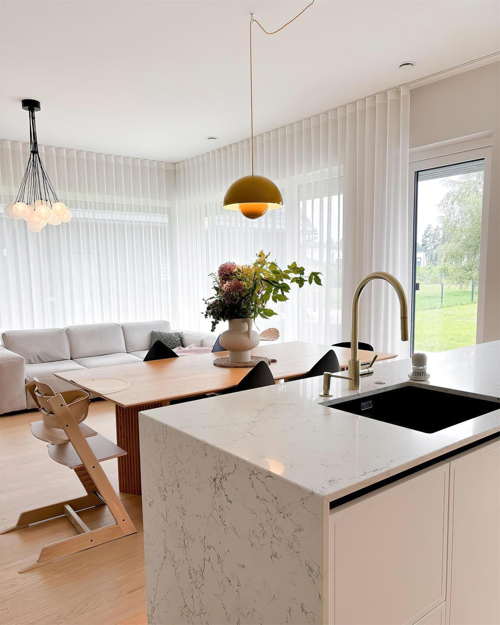 The Clérachic Flowerpot pendant in yellow, plugged in above an open dining and kitchen space.