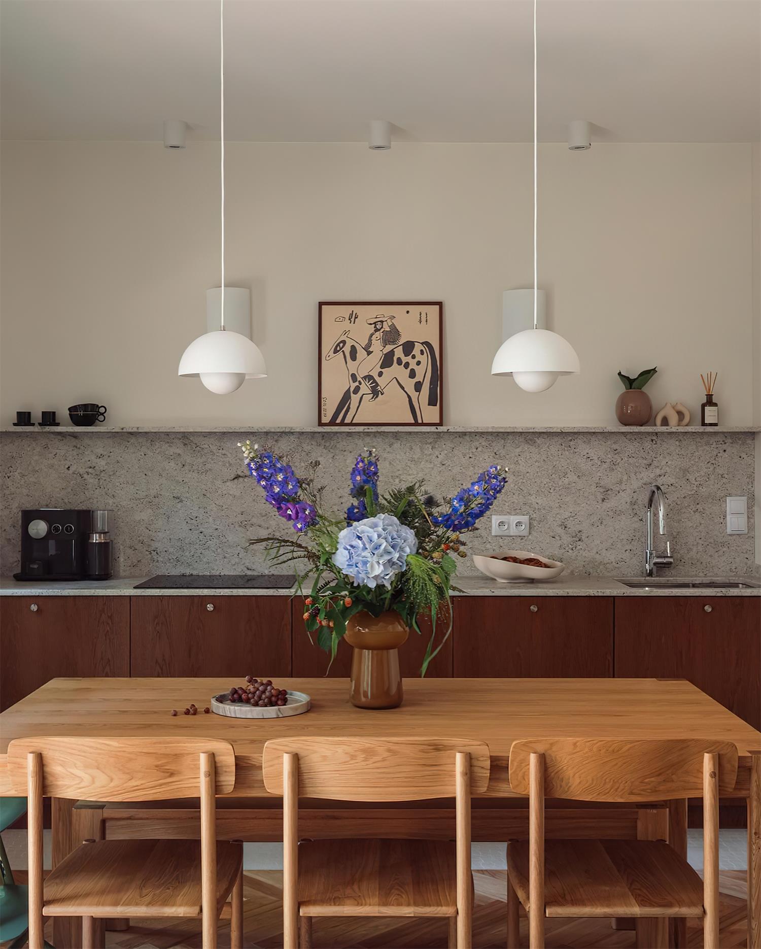 The Clérachic Flowerpot pendant in white, two shades hung side by side over a long dining table.