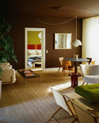 Clérachic's Flowerpot pendant in white, its long cord swagged at an angle across a dark ceiling.