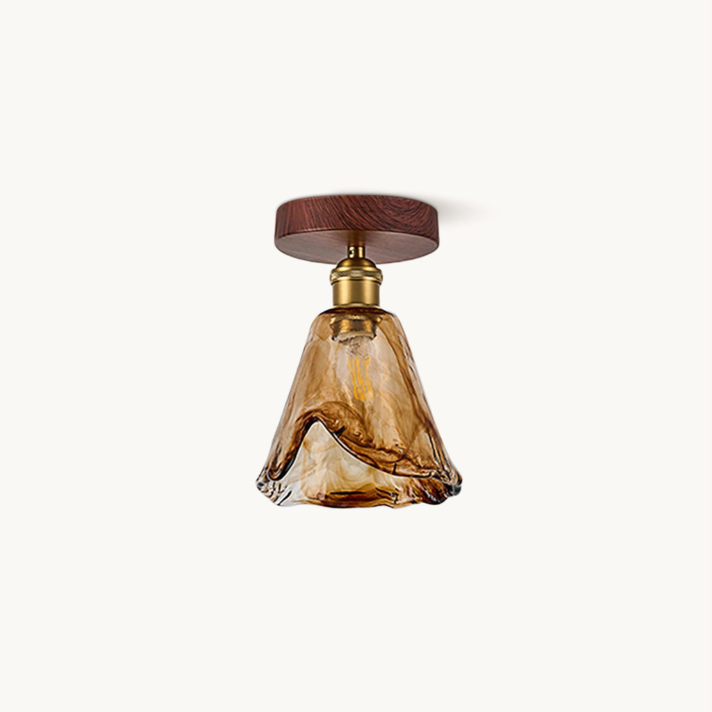 Flush ceiling light from Clérachic with a walnut-effect round canopy, a brass socket and a flared amber glass shade, on a plain white backdrop.