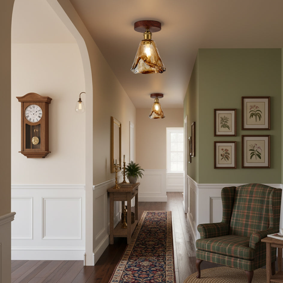 Amber glass flush ceiling lights from Clérachic with walnut-effect canopies, lit along a hallway with a clock, a tartan armchair and a runner.