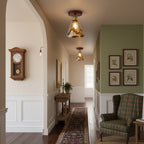 Amber glass flush ceiling lights from Clérachic with walnut-effect canopies, lit along a hallway with a clock, a tartan armchair and a runner.
