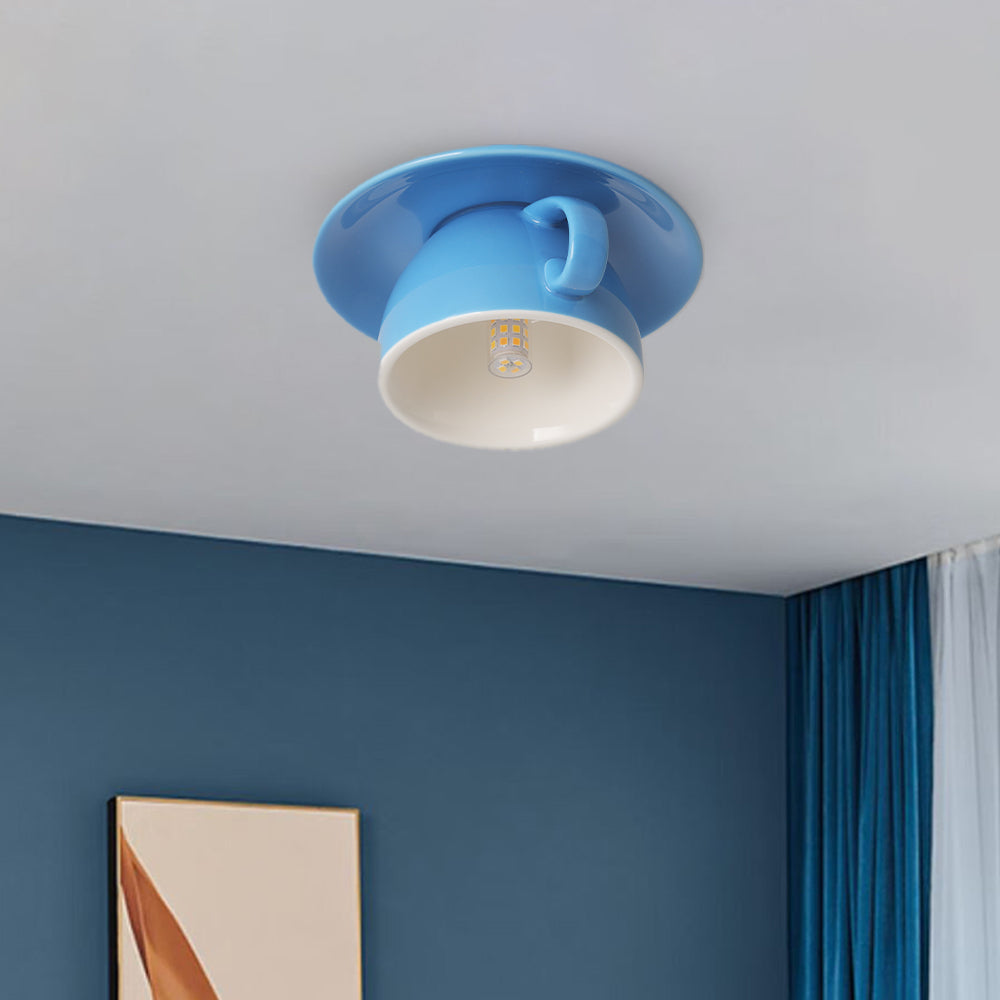 Clérachic's sky-blue coffee-cup flush mount glows above a dining corner with deep blue walls.