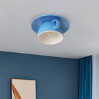 Clérachic's sky-blue coffee-cup flush mount glows above a dining corner with deep blue walls.