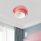 The Clérachic pink coffee-cup ceiling light brightens a bedroom with blue and pink accent walls.