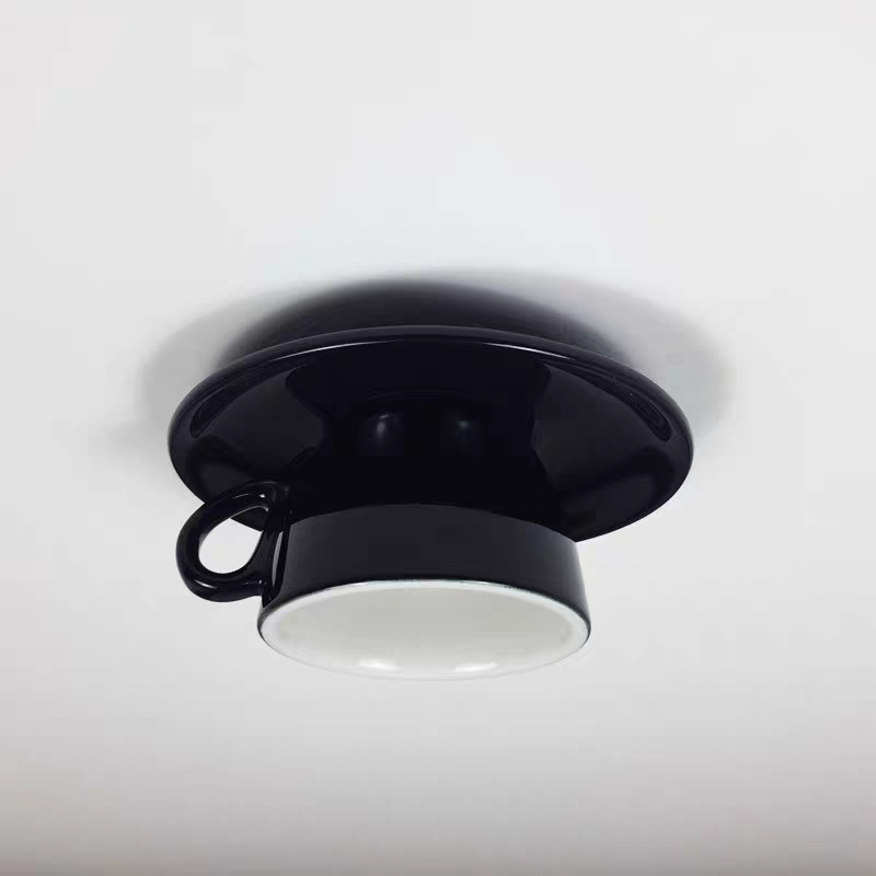 Clérachic's black ceramic coffee-cup light shows its glossy glaze and looped handle up close.