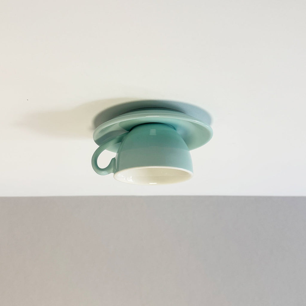 Clérachic's light blue coffee-cup flush mount sits against a soft gray ceiling backdrop.