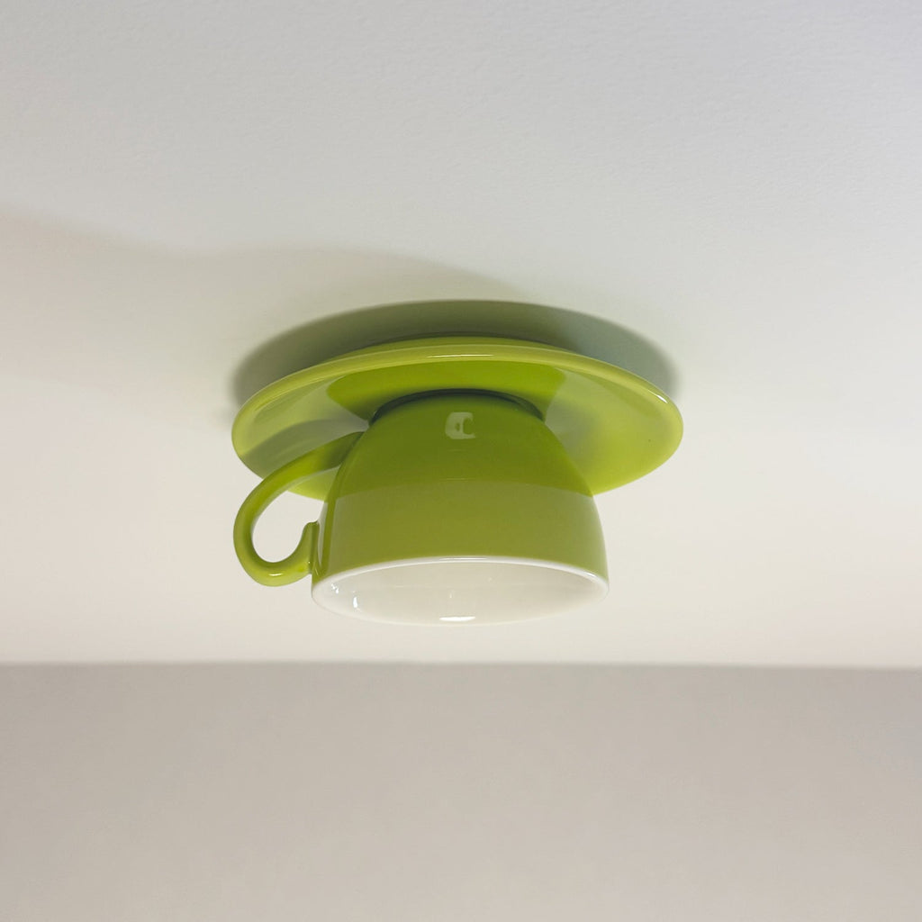 The Clérachic light green coffee-cup ceiling light shows its curved handle against gray.