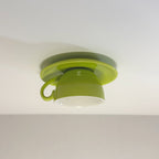The Clérachic light green coffee-cup ceiling light shows its curved handle against gray.