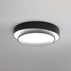 The Clérachic double-ring ceiling light in black glows warm, its two rings caught face-on.