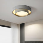 Clérachic's gray double-ring flush mount lights a bedroom corner beside a sheer white curtain.