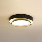 The Clérachic black double-ring ceiling light glows warm against a soft amber-toned ceiling.