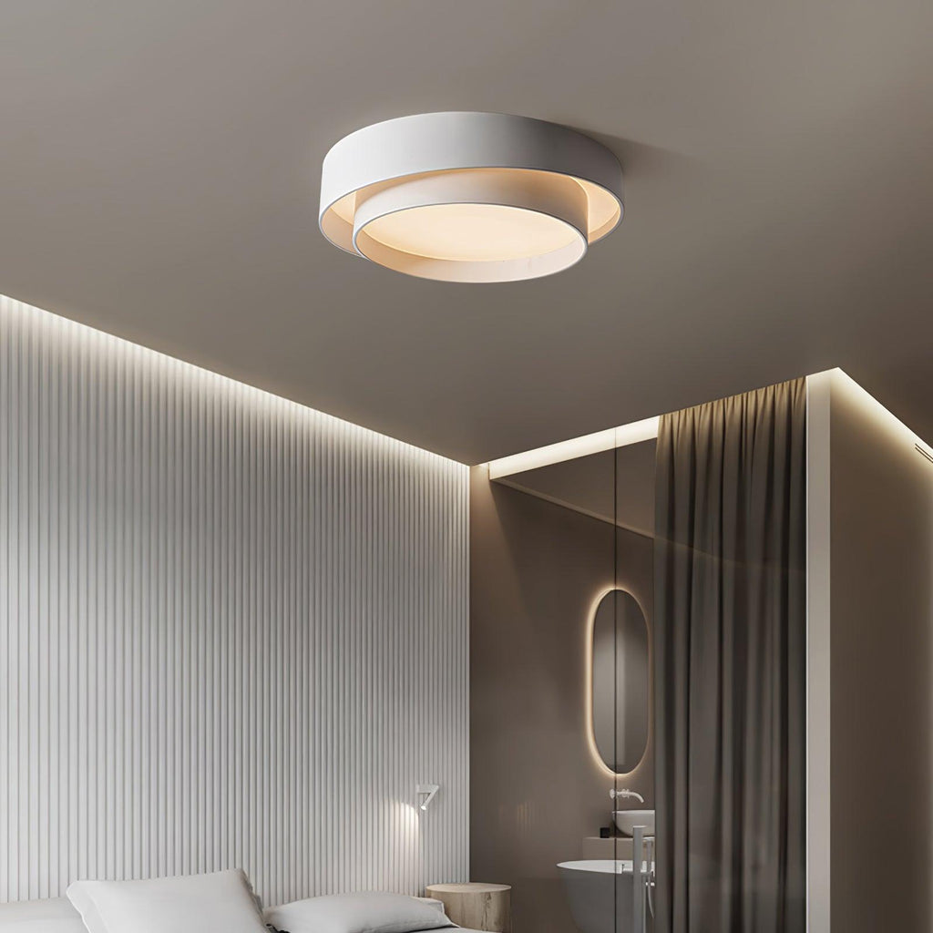 The Clérachic gray double-ring ceiling light glows warm above a bedroom curtain and headboard.