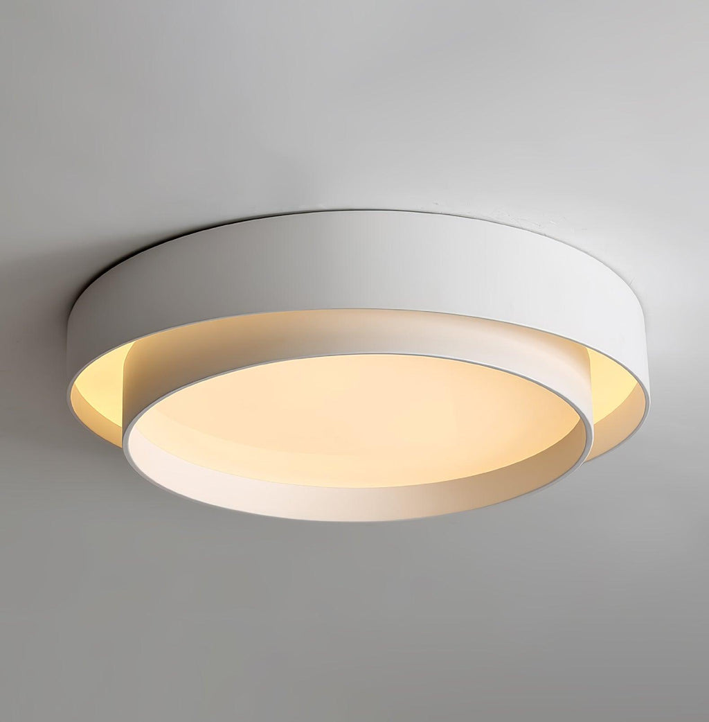The Clérachic gray double-ring ceiling light is shown close up, the diffuser glowing warm.