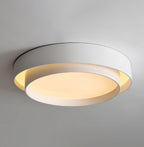 The Clérachic gray double-ring ceiling light is shown close up, the diffuser glowing warm.