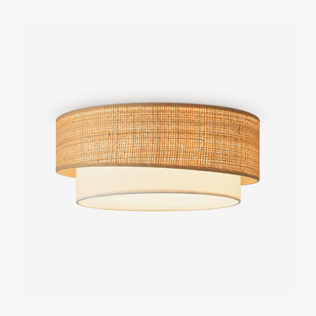 Product view of this Clérachic ceiling light showing its woven beige raffia drum sitting over a white fabric lower tier.