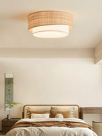 This Clérachic flush-mount lights a neutral bedroom corner, its beige raffia drum sitting close against the ceiling.