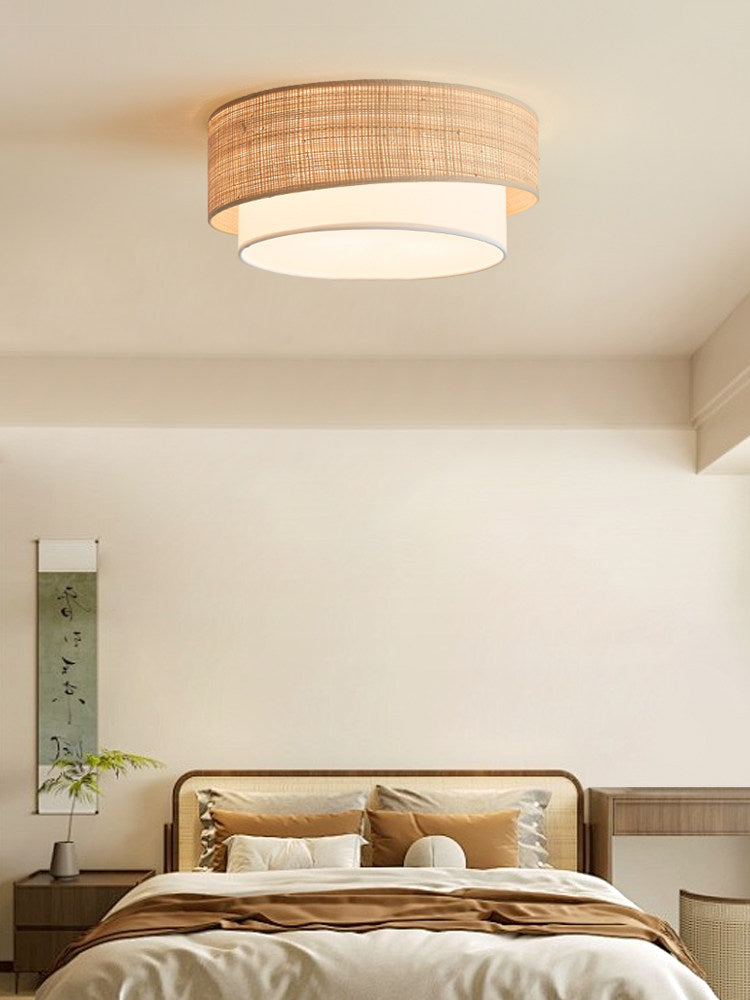 This Clérachic flush-mount lights a neutral bedroom corner, its beige raffia drum sitting close against the ceiling.