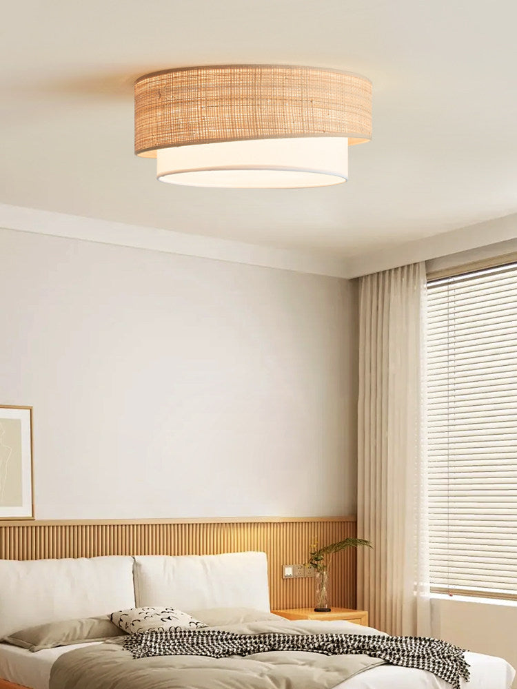 This Clérachic ceiling light glows above a bedroom with a woven headboard and blinds filtering the window light.