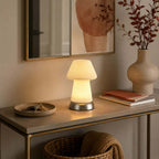 On a console table with a mirror, terracotta-toned art and a stoneware vase, this Clérachic cordless lamp glows beside books and a dish of keys.