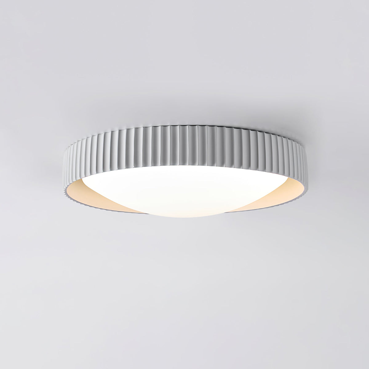 A pale grey Clérachic flush ceiling light seen from below, its ribbed drum rim sitting low and flat to a light grey ceiling.
