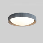 A blue-grey Clérachic flush ceiling light with a ribbed rim and white diffuser, shown on a mid-grey backdrop.