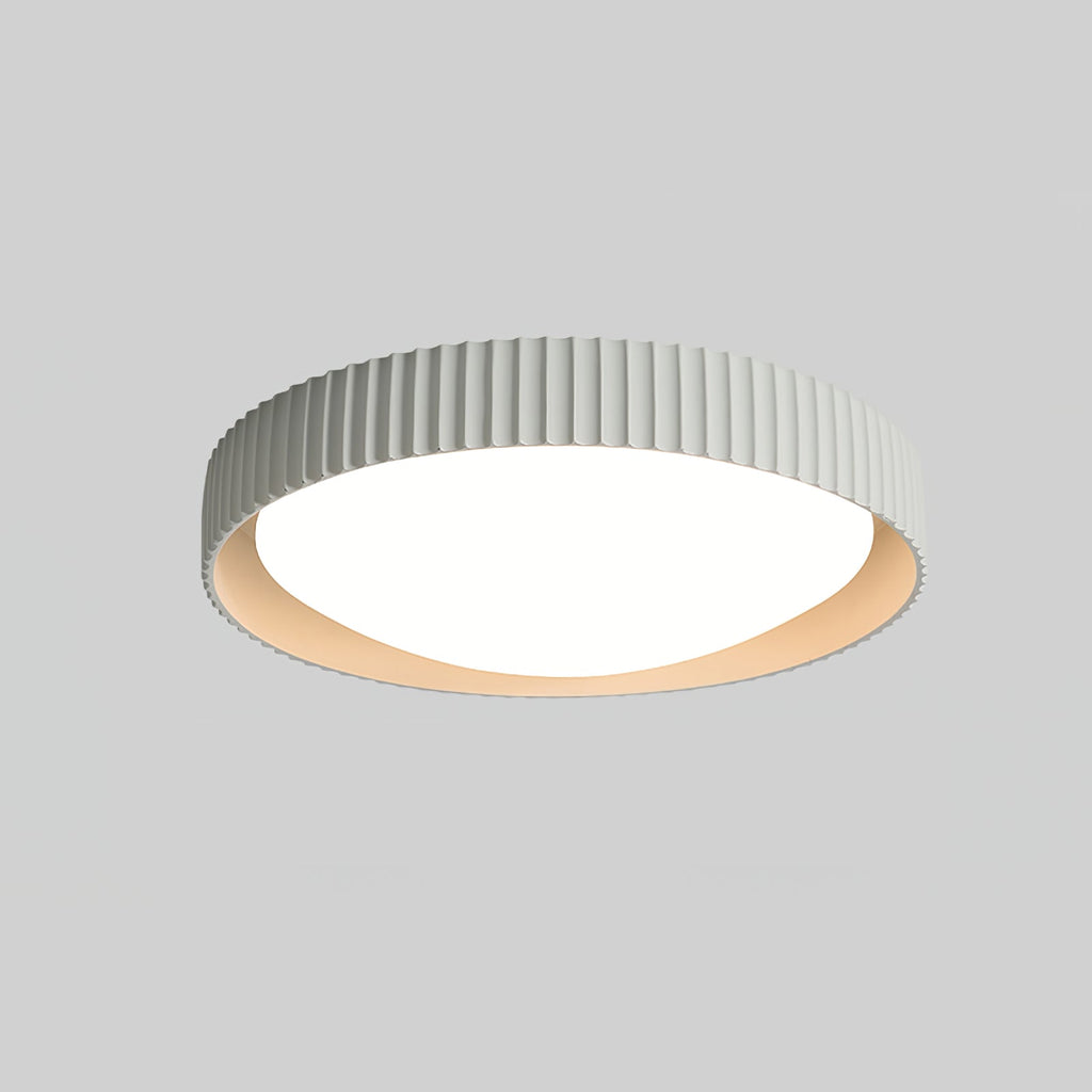 A Clérachic flush ceiling light in a very pale grey-white, its ribbed rim and diffuser seen from below against a mid-grey backdrop.
