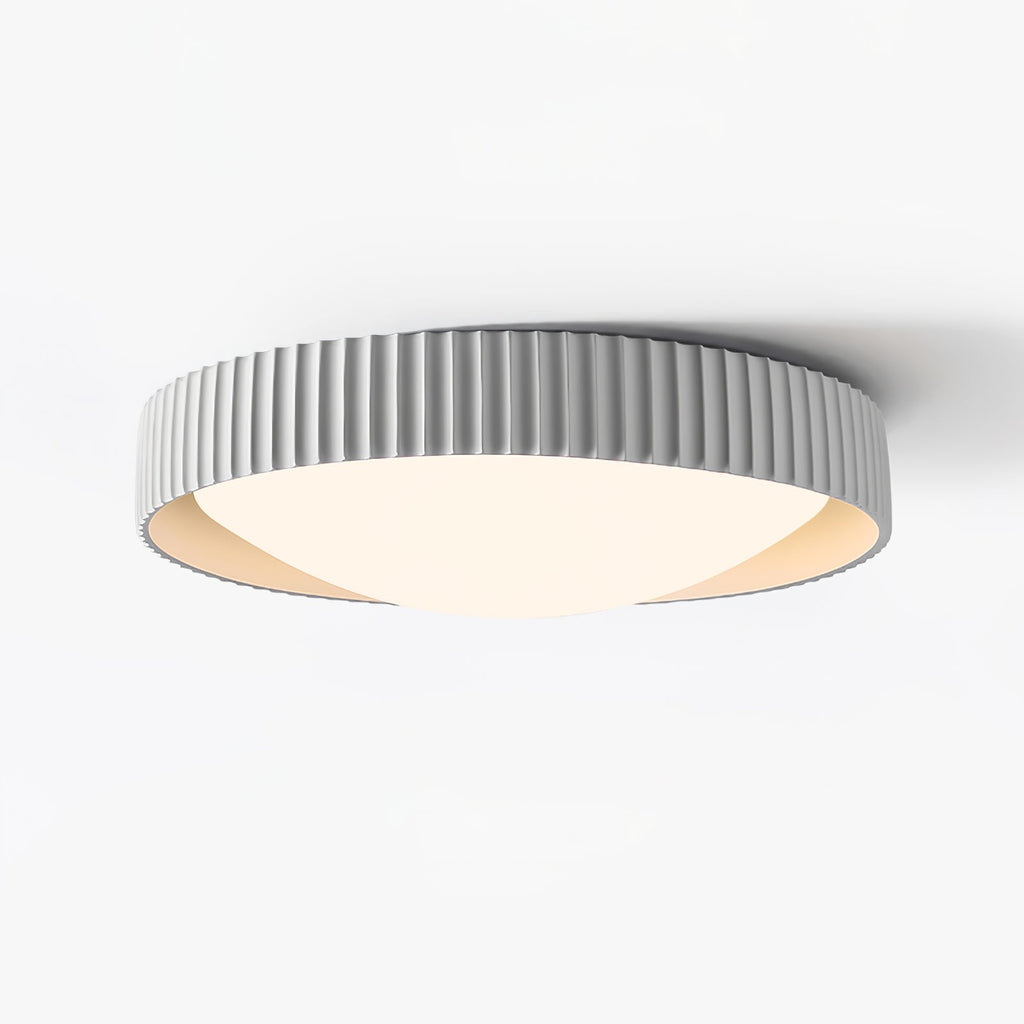 This pale grey Clérachic flush ceiling light on a white backdrop, with a ribbed edge and a warm cream inner rim around the diffuser.