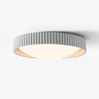 This pale grey Clérachic flush ceiling light on a white backdrop, with a ribbed edge and a warm cream inner rim around the diffuser.
