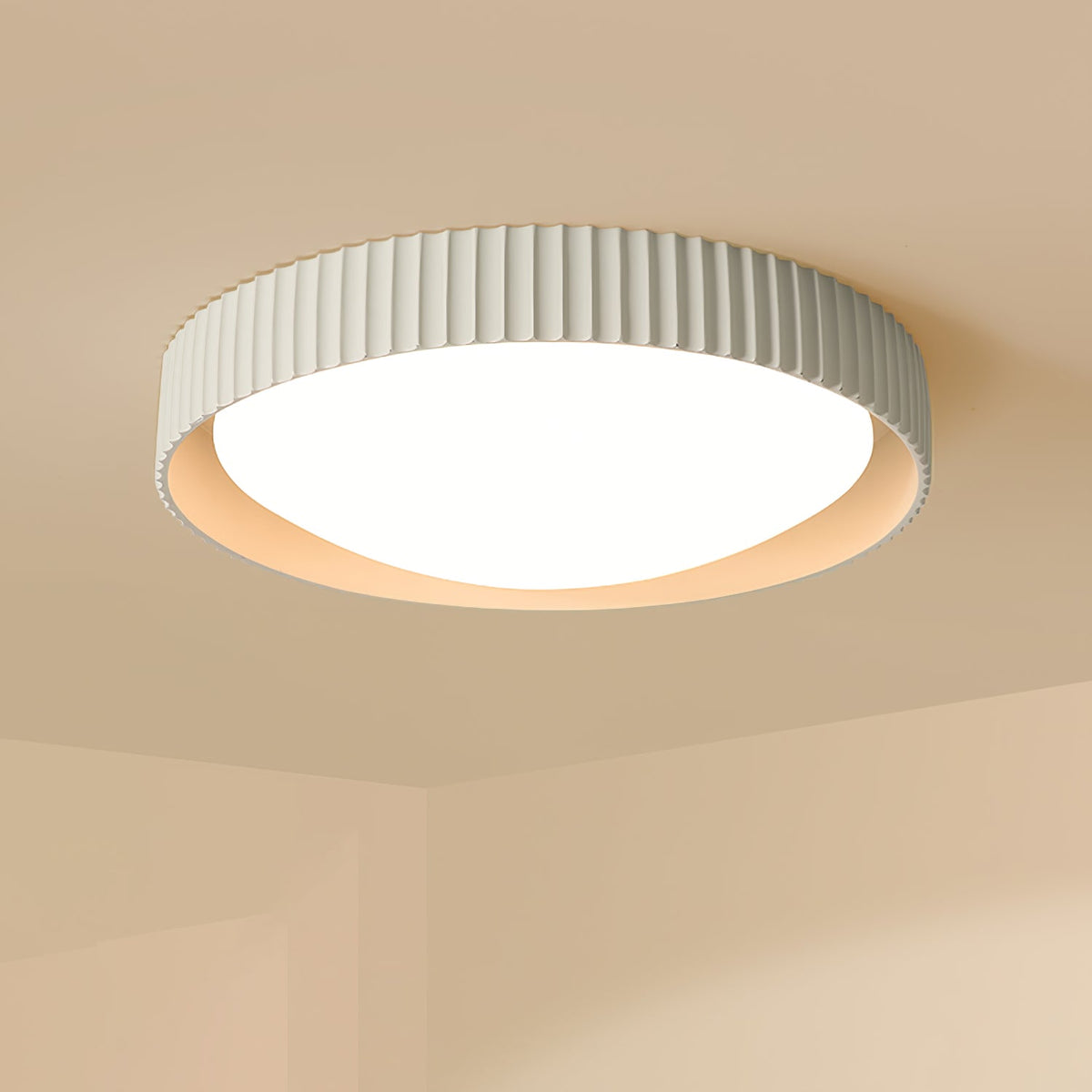 Close view of a pale grey Clérachic flush ceiling light on a warm sand-coloured ceiling, its ribbed rim and diffuser lit.