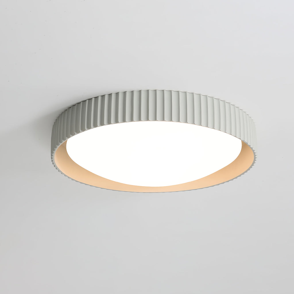 Pale grey Clérachic ribbed flush ceiling light from below, its slim rim and lit white diffuser glowing on a light grey ceiling.