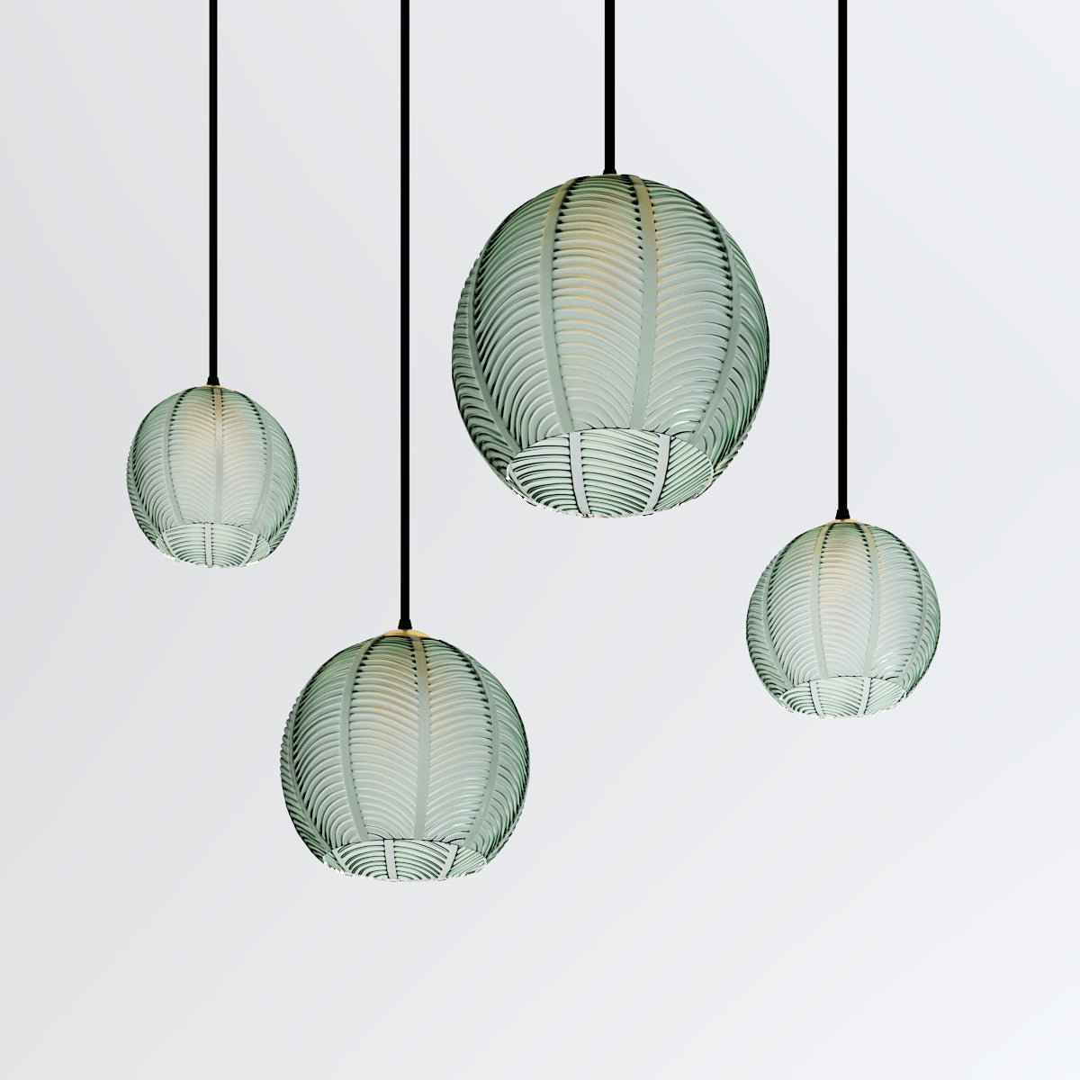 Clérachic ribbed opaline glass pendant lights in sage green shown as a cluster of four, staggered heights, unlit on white.