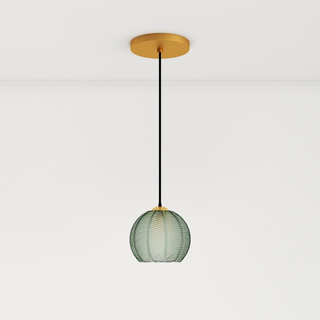 Clérachic ribbed opaline glass pendant light in sage green on a long black cord from a brass ceiling canopy, unlit.