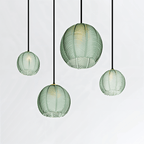 Clérachic ribbed opaline glass pendant lights in sage green, four fixtures glowing warm together against white.