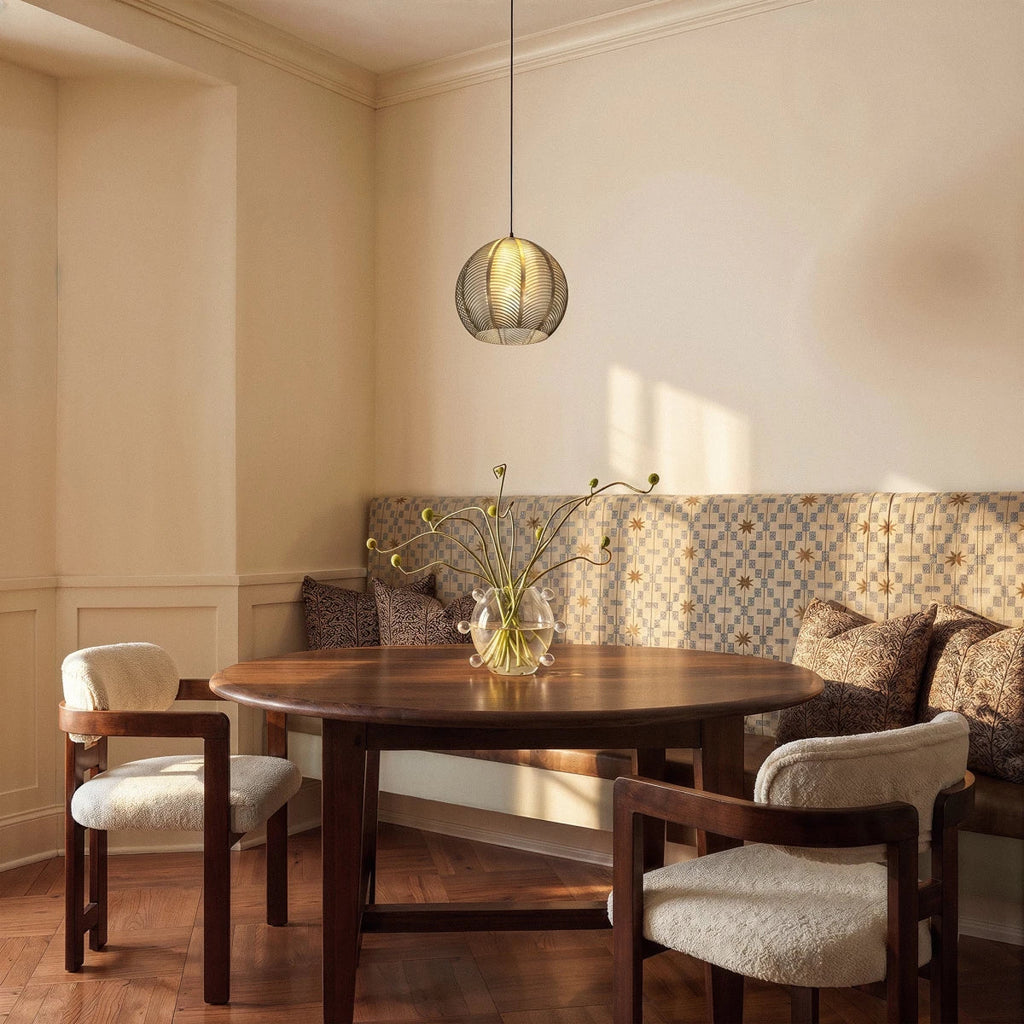 Clérachic ribbed opaline glass pendant light in sage green hung low over a round wood dining table at golden hour.
