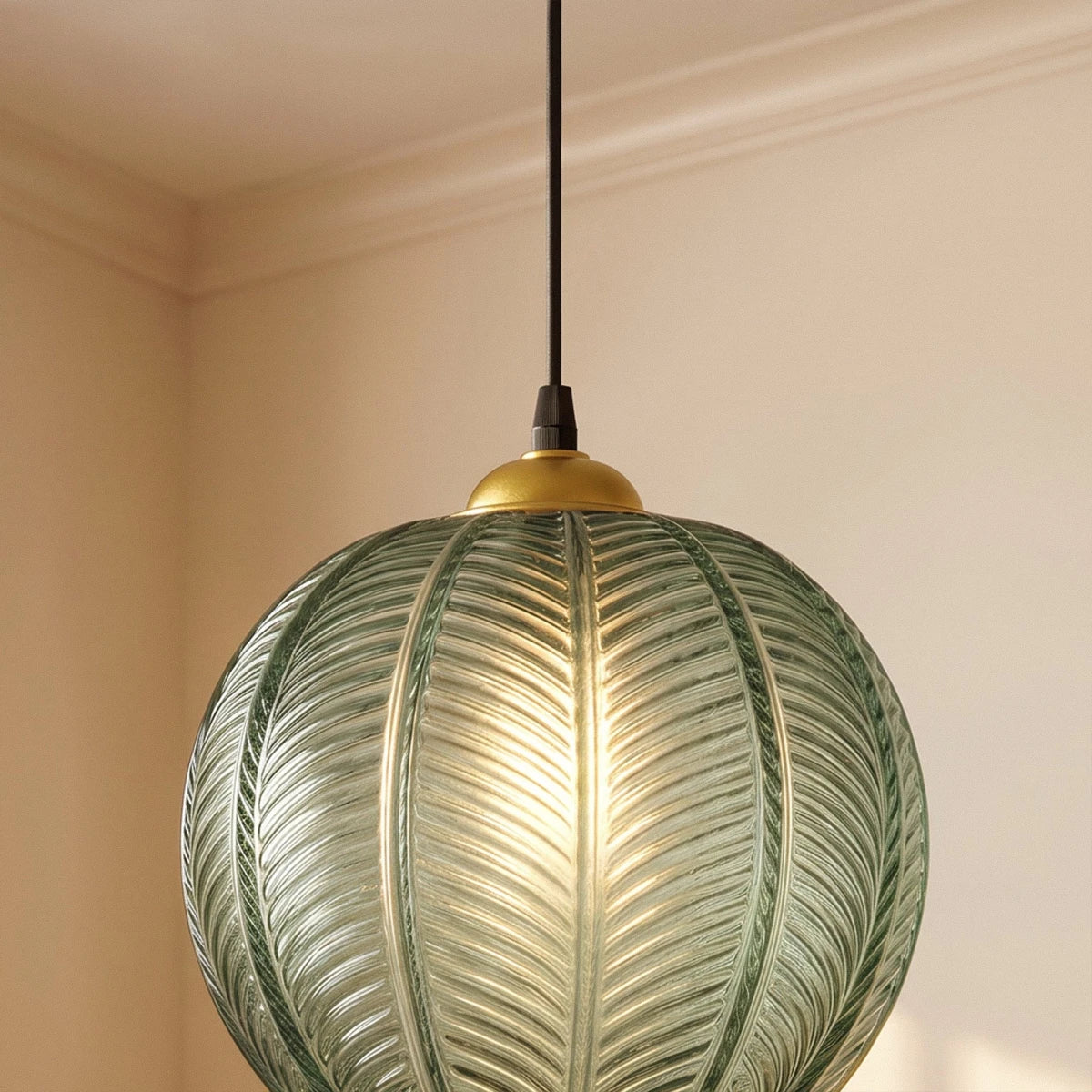 Clérachic ribbed opaline glass pendant light in sage green on its brass ceiling canopy, close against a plain wall corner.
