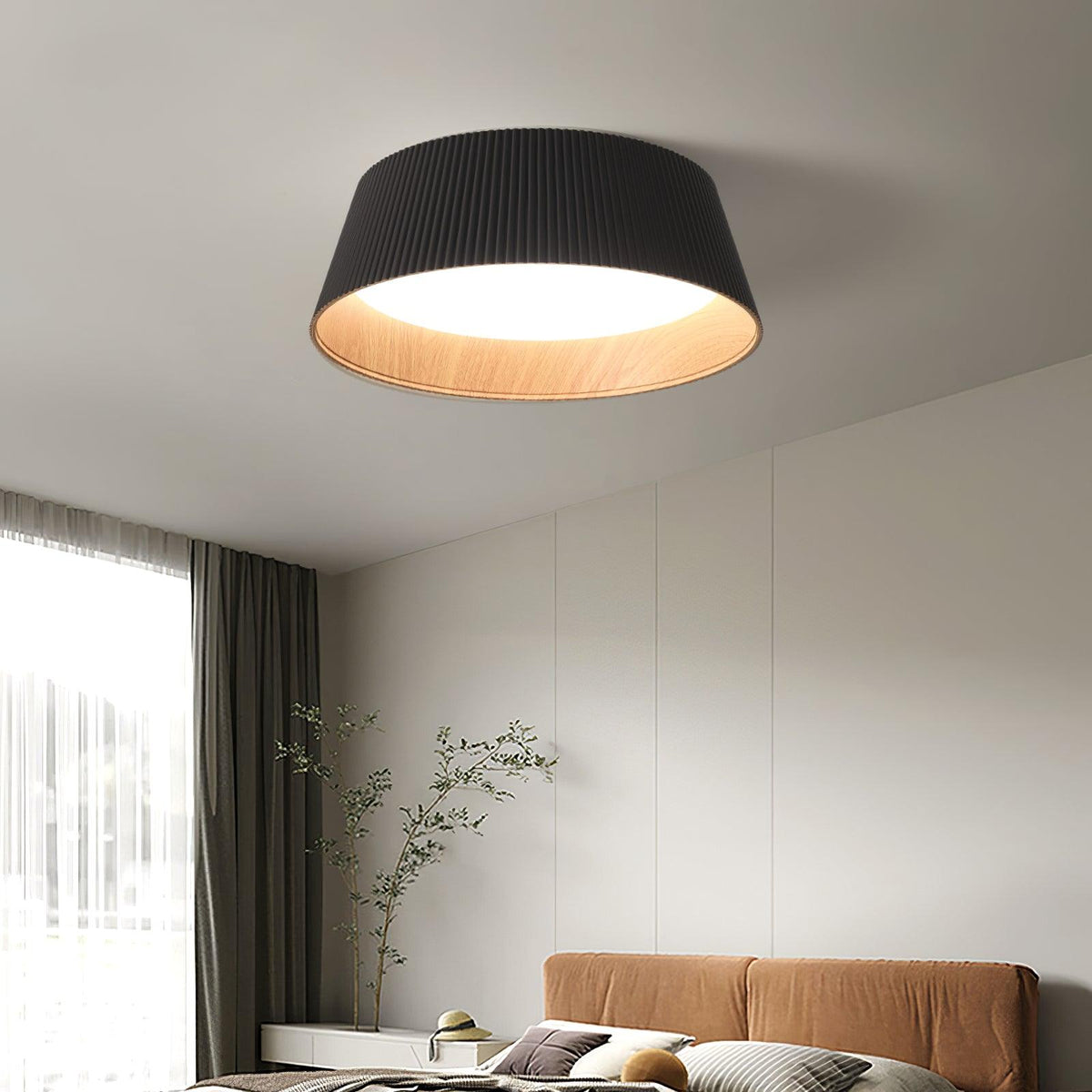 Black Clérachic ceiling light with a wood-grain interior over a bedroom with a tan headboard, a tall window and grey curtains.