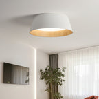 White fluted Clérachic ceiling light in a room with a wall-mounted television, a potted tree and sheer curtains.