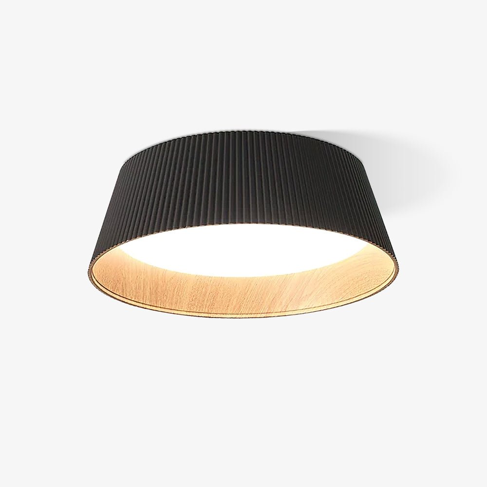 Black Clérachic ceiling light, ribbed on the outside, with a warm wood-grain interior and a bright diffuser, on a plain backdrop.