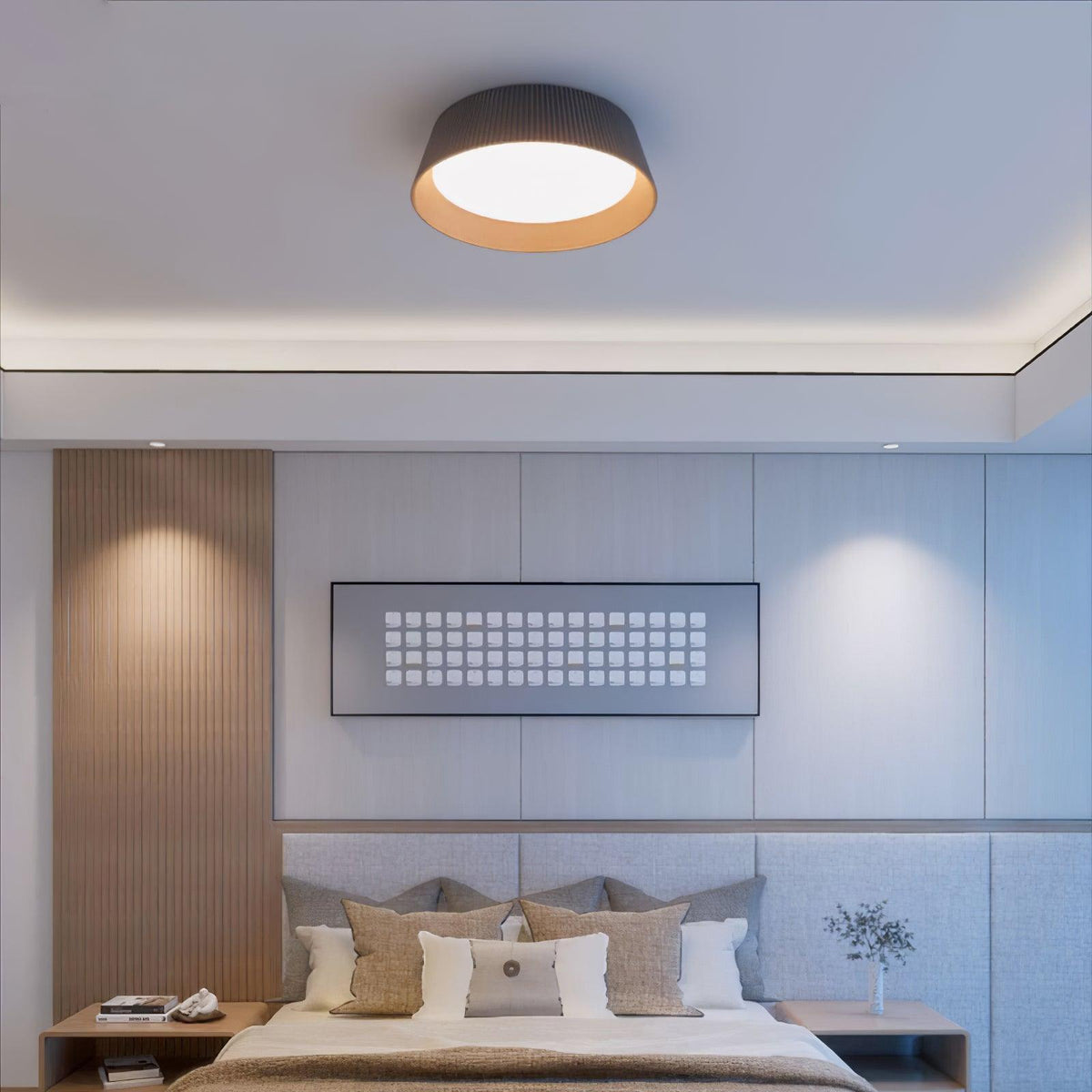 Black Clérachic ceiling light above a bedroom with a slatted wood panel, a grey padded headboard and a framed grid artwork.