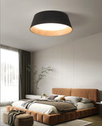 A black Clérachic ceiling light above a bedroom with a terracotta-coloured bed, a tall window and a grey wardrobe wall.