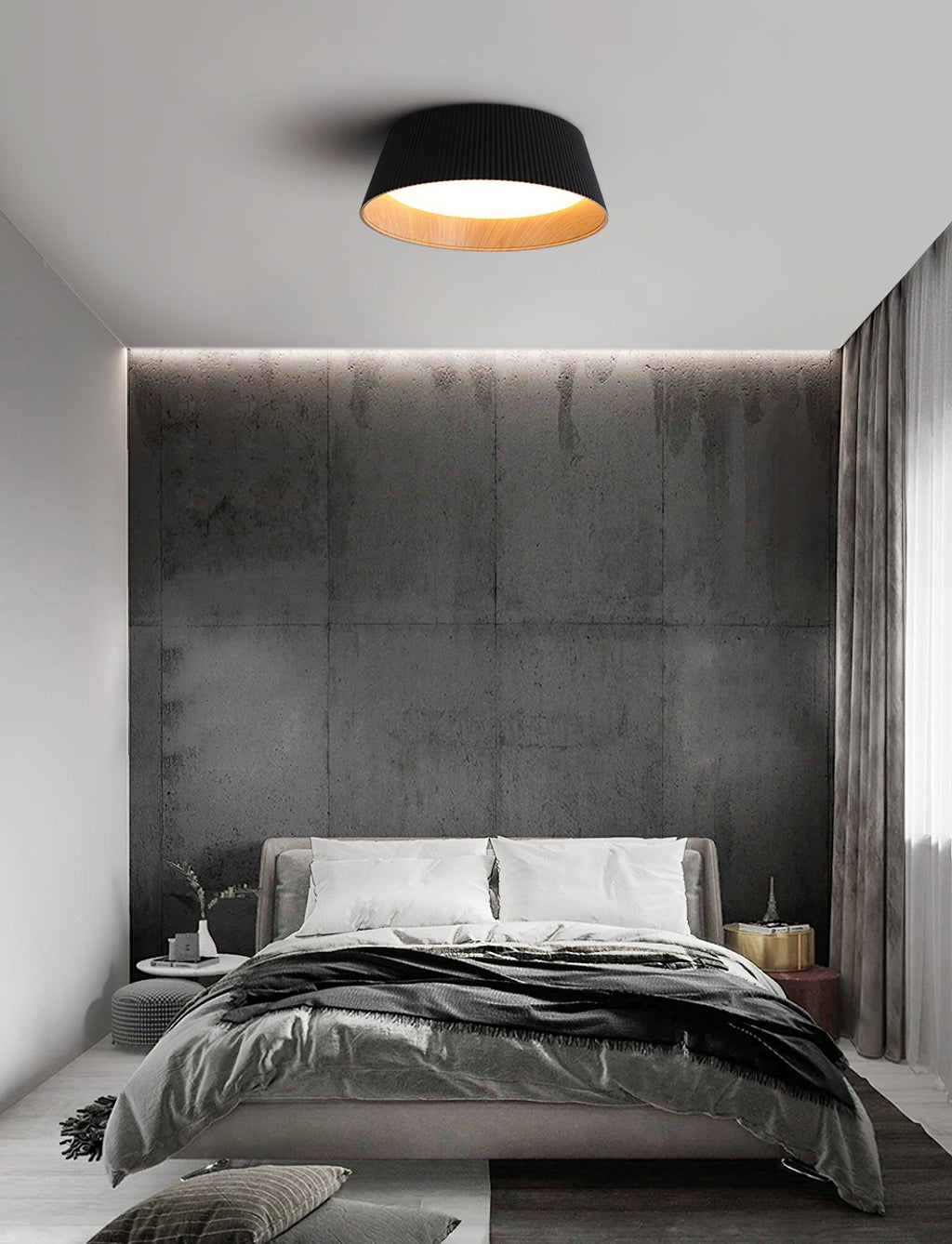 Black Clérachic ceiling light over a dark bedroom with a concrete-look wall, a grey bed and a curtain at the right.