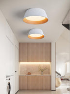 Two white Clérachic ceiling lights, one above the other, in a corridor with timber cabinets and a washing machine.