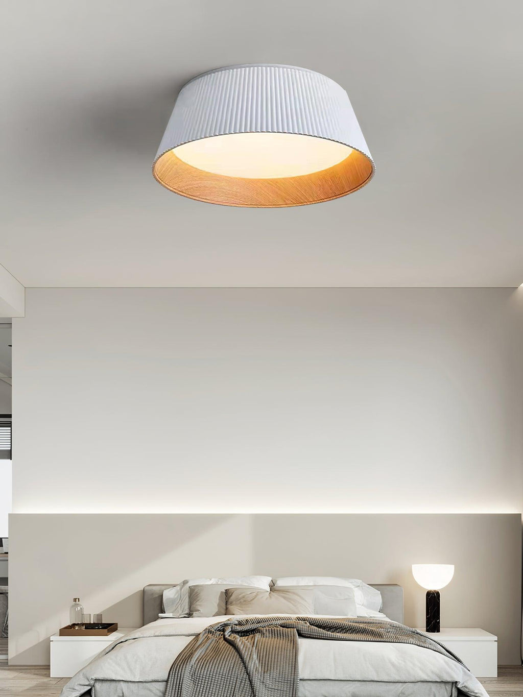 White Clérachic ceiling light above a pale bedroom with a grey bed, a throw and a black table lamp on the bedside.