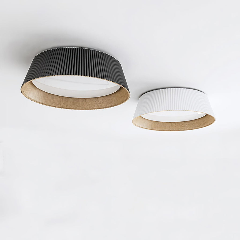 A black and a white Clérachic ceiling light side by side, both with wood-grain interiors, on a light ceiling.