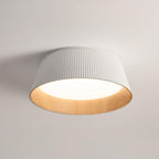 White fluted Clérachic ceiling light seen from below, its wood-grain inner rim and diffuser clear against the ceiling.