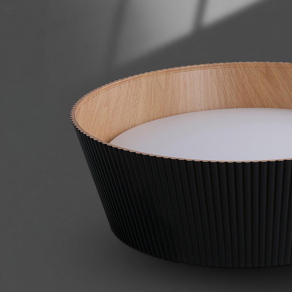 Close view of the black fluted outer wall, wood-grain inner rim and frosted diffuser of this Clérachic ceiling light.