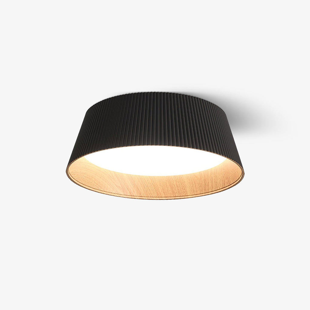 Black fluted Clérachic ceiling light with a lit diffuser and wood-grain interior, on a plain light backdrop.