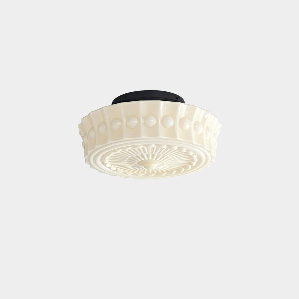The beige Clérachic fluted opal glass flush ceiling light angled to reveal its ribbed drum and sunburst underside.