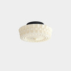 The beige Clérachic fluted opal glass flush ceiling light angled to reveal its ribbed drum and sunburst underside.